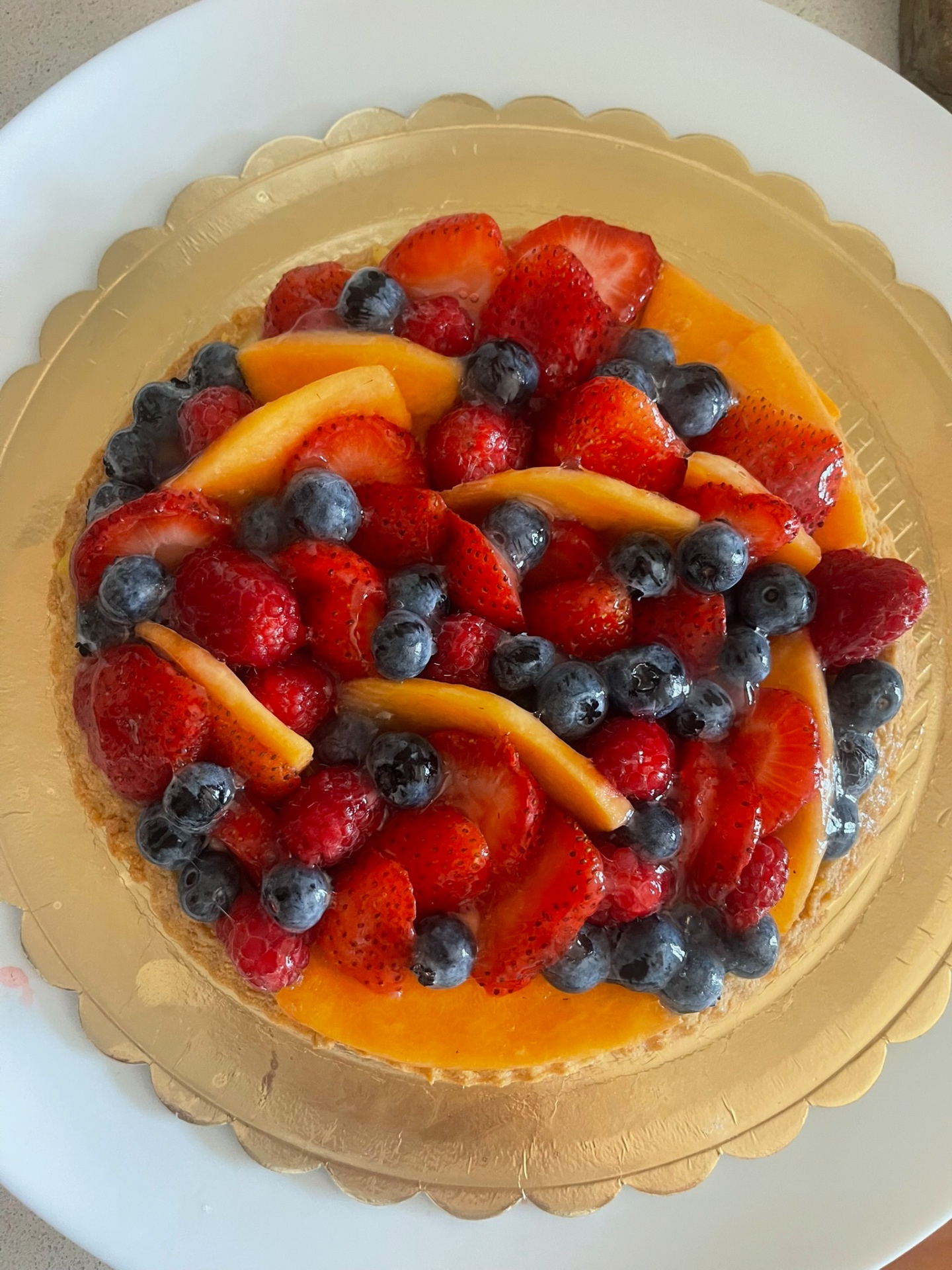 Crostata con crema, pesche, fragole e mirtilli