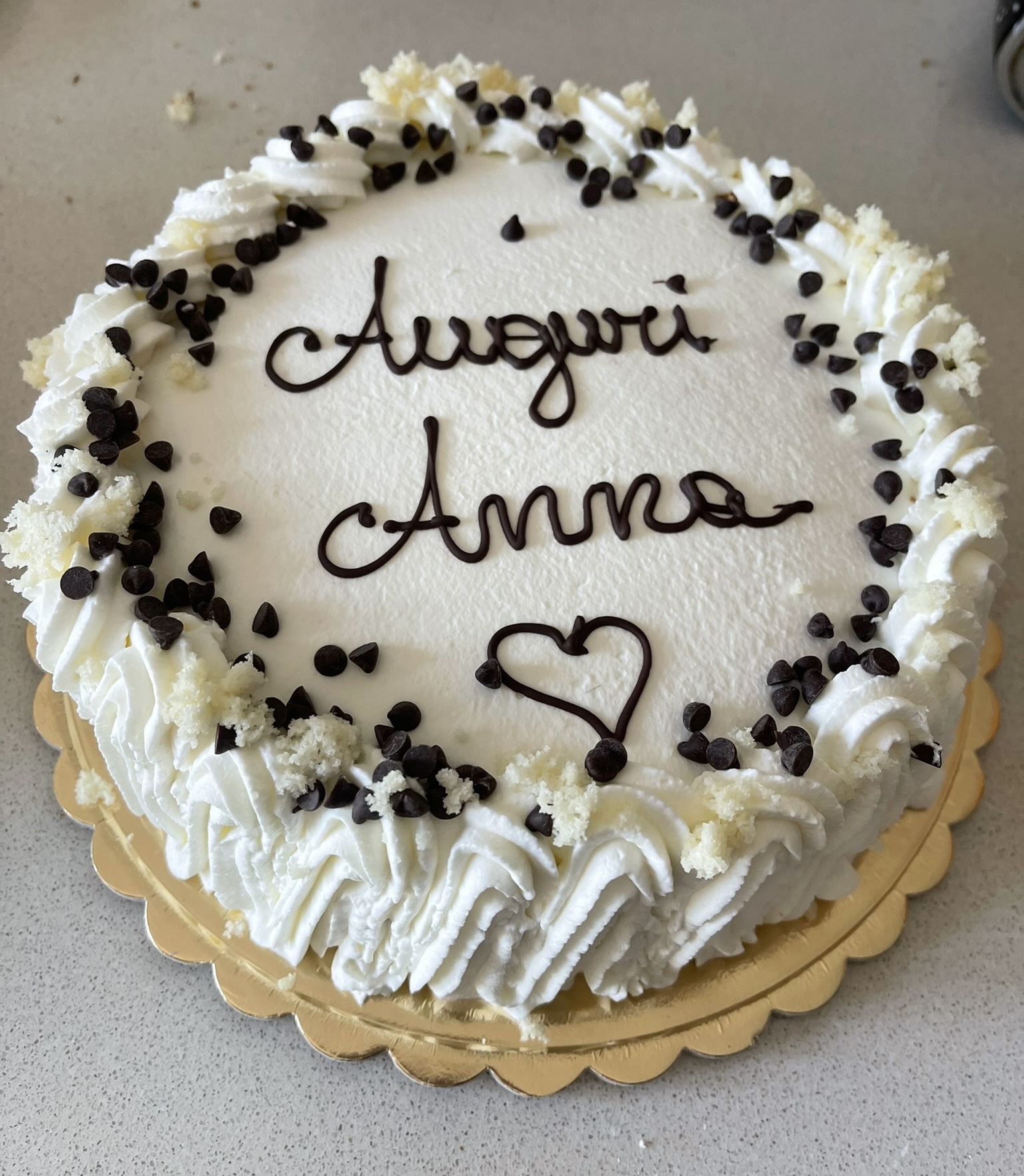 Torta alla panna con gocce di cioccolato e scritta Auguri Anna