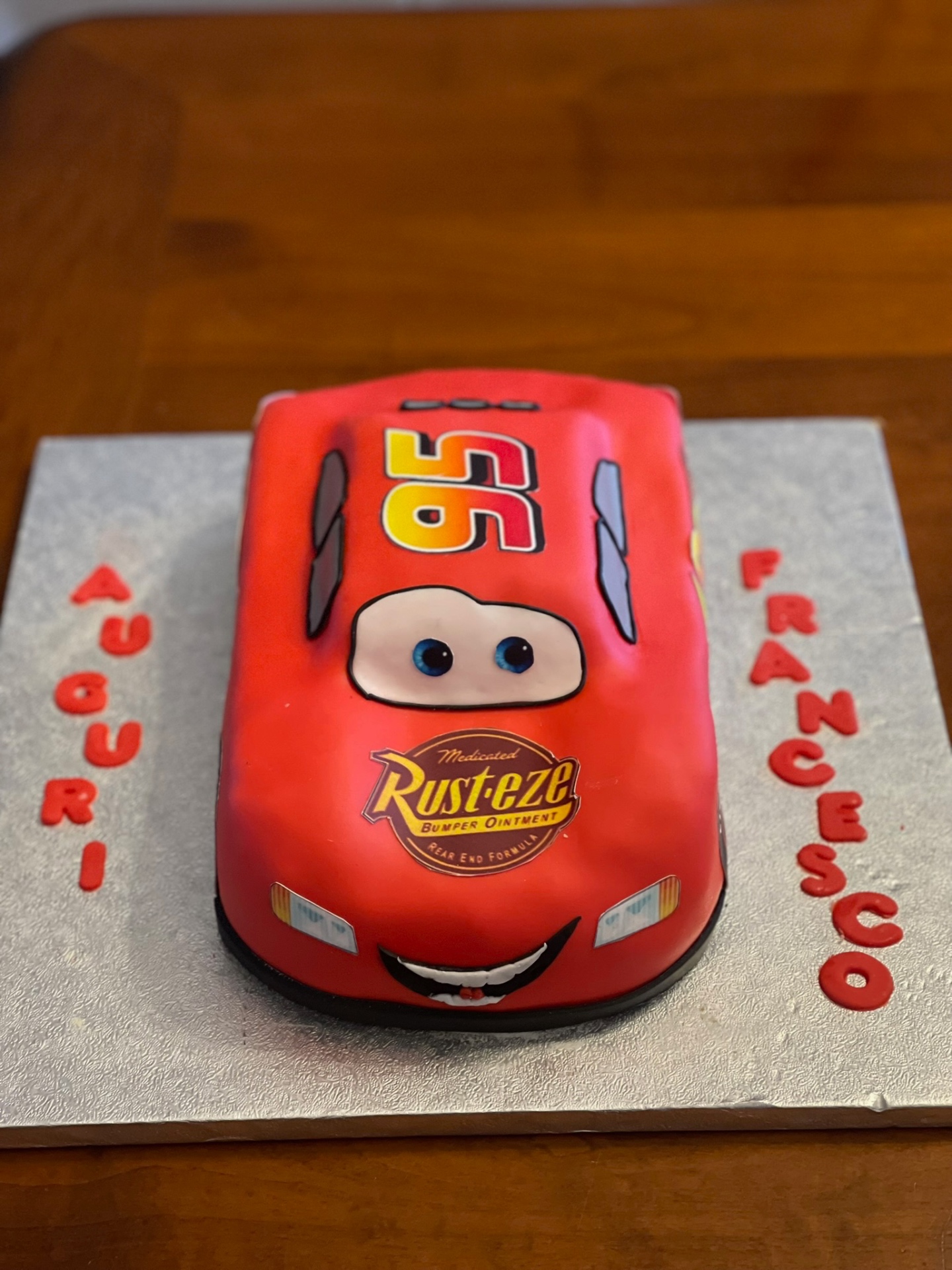 Torta a forma di macchina rossa di Cars con scritta Auguri Francesco