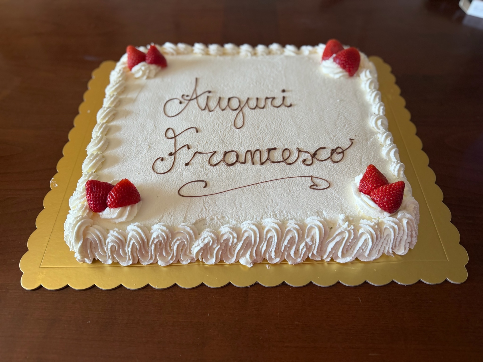 Torta rettangolare alla panna montata con scritta Auguri Francesco